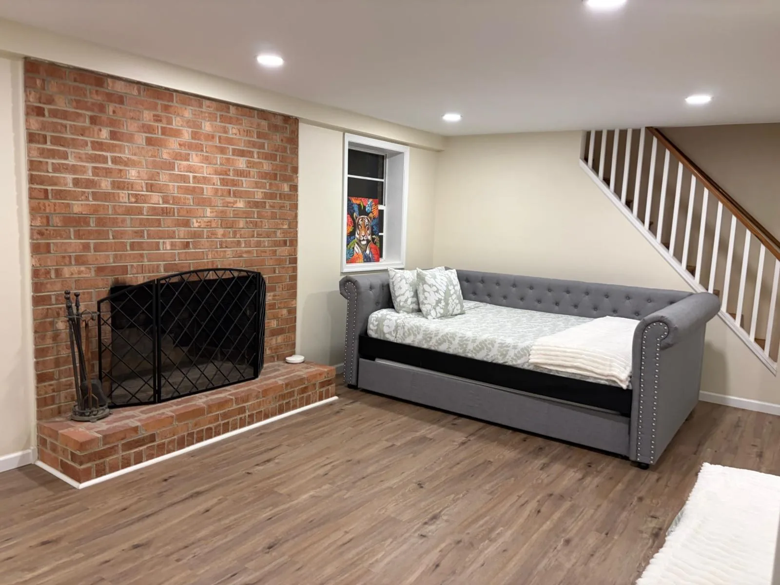 Basement living area with brick fireplace
